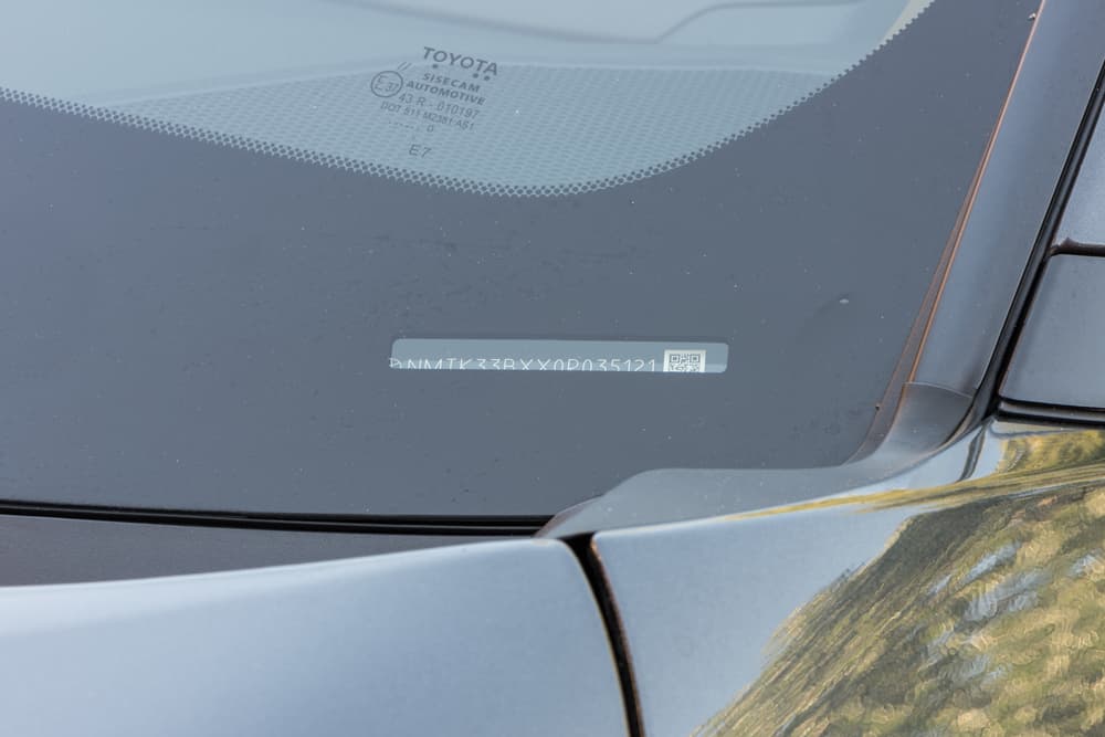 Toyota Avalon VIN plate visible through the windshield on the driver's side dashboard